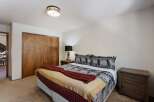 This cozy bedroom features a comfortable bed with a unique patterned comforter and decorative pillows.