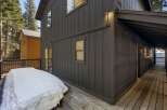 This stunning property boasts a modern exterior with dark siding and a spacious deck, perfect for enjoying the outdoors.