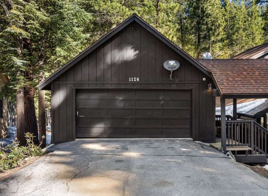This stunning property boasts a charming exterior with a dark-colored garage door and a welcoming entrance.