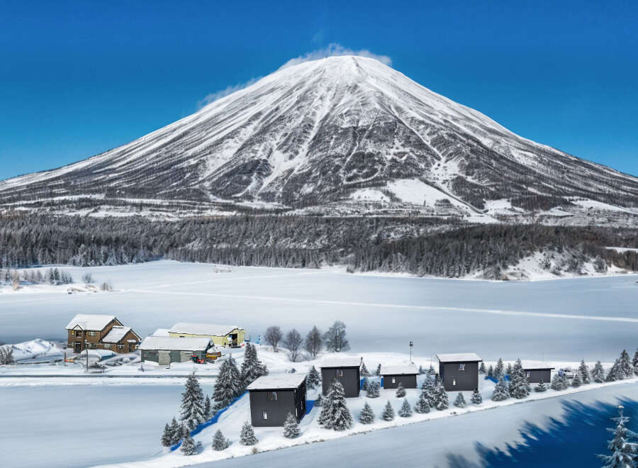 Nestled in a serene winter wonderland, this property offers stunning views of a snow-capped mountain and a pristine, frozen lake.