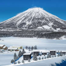 Nestled in a serene winter wonderland, this property offers stunning views of a snow-capped mountain and a pristine, frozen lake.