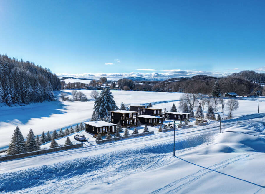 Discover a stunning winter retreat with modern homes nestled in a snowy landscape.