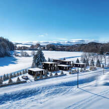 Discover a stunning winter retreat with modern homes nestled in a snowy landscape.