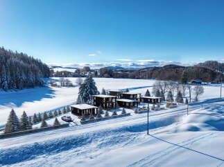 Discover a stunning winter retreat with modern homes nestled in a snowy landscape.