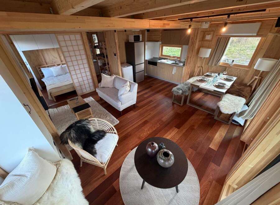 Step into this cozy cabin retreat, showcasing a warm and inviting interior with beautiful wooden floors and walls.