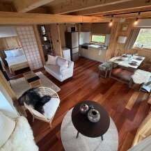 Step into this cozy cabin retreat, showcasing a warm and inviting interior with beautiful wooden floors and walls.