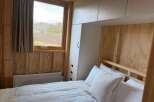 This cozy bedroom features a comfortable bed with soft white pillows, perfect for a relaxing retreat.