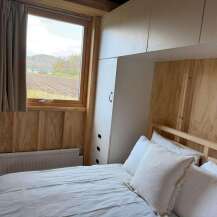 This cozy bedroom features a comfortable bed with soft white pillows, perfect for a relaxing retreat.