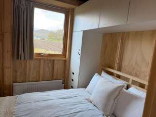 This cozy bedroom features a comfortable bed with soft white pillows, perfect for a relaxing retreat.