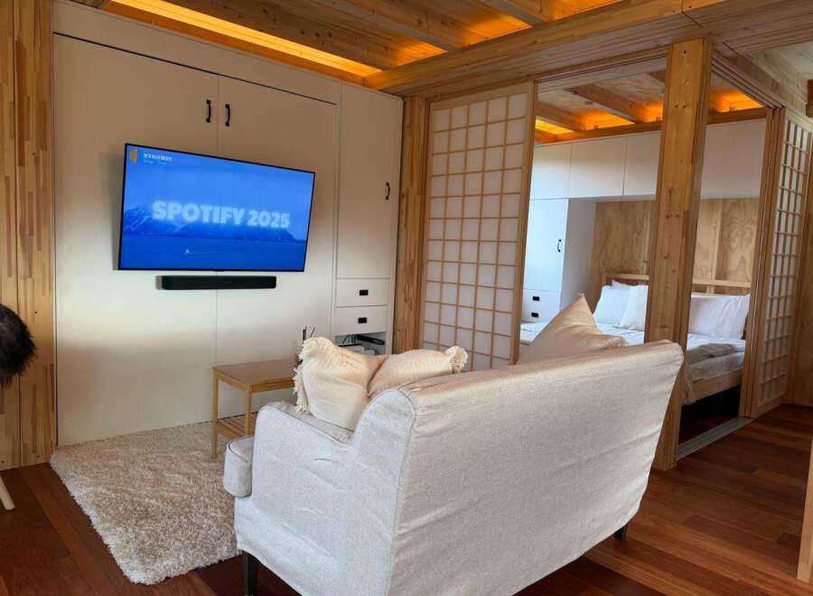 This cozy living space features a modern design with a built-in entertainment center and a comfortable sofa.