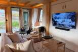 Experience modern living in this stylish property, featuring a cozy living room with a comfortable sofa and a sleek entertainment setup.