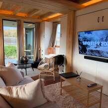 Experience modern living in this stylish property, featuring a cozy living room with a comfortable sofa and a sleek entertainment setup.