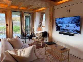 Experience modern living in this stylish property, featuring a cozy living room with a comfortable sofa and a sleek entertainment setup.