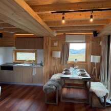 Step into this cozy cabin retreat, featuring a warm wooden interior and modern amenities.