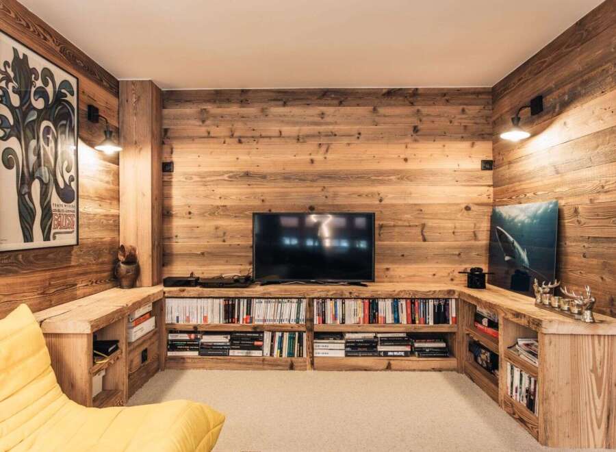 This stunning living room boasts a rustic, inviting ambiance with its warm wooden paneling and built-in shelving.