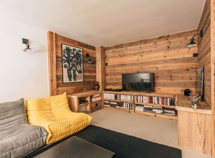 This cozy living space features a stunning wooden accent wall, creating a warm and inviting atmosphere.