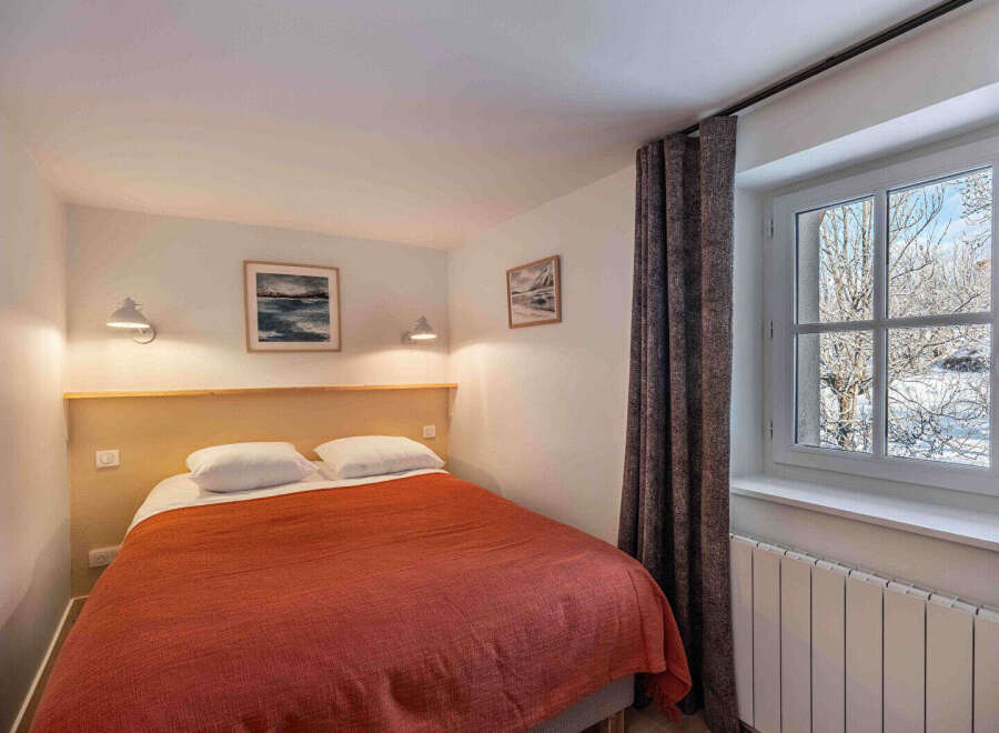 This cozy bedroom offers a comfortable retreat with its inviting ambiance and tasteful decor.