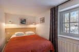 This cozy bedroom offers a comfortable retreat with its inviting ambiance and tasteful decor.