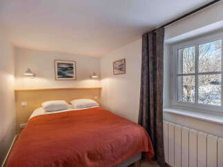 This cozy bedroom offers a comfortable retreat with its inviting ambiance and tasteful decor.