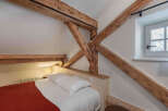 This charming bedroom features exposed wooden beams, adding rustic character and warmth to the space.