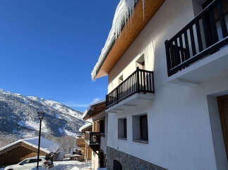 Experience the charm of a winter wonderland with this stunning property nestled in a snowy mountain landscape.