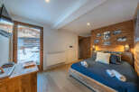 Experience the ultimate comfort in this cozy bedroom, featuring a rustic wooden accent wall and a plush bed.