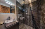 Step into luxury with this stunning bathroom! Featuring sleek black tile, a modern sink, and a spacious shower, this space is designed for ultimate relaxation.