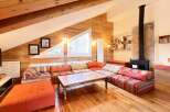 This stunning property boasts a unique, cozy living space with exposed wooden beams and walls, creating a warm and inviting atmosphere.