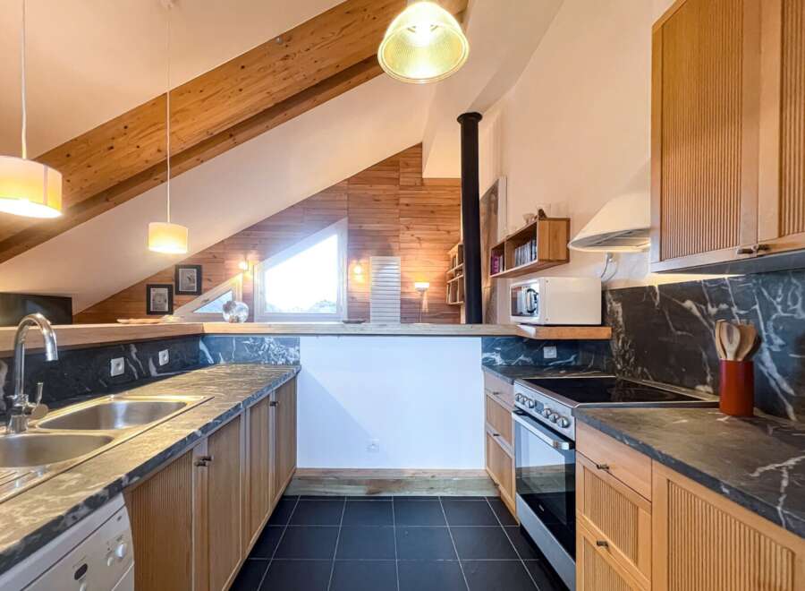 Discover this stunning kitchen with a unique design, featuring wooden beams and a modern aesthetic.
