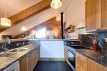 Discover this stunning kitchen with a unique design, featuring wooden beams and a modern aesthetic.
