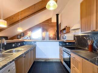 Discover this stunning kitchen with a unique design, featuring wooden beams and a modern aesthetic.