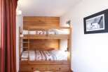 This cozy bedroom features a custom-built wooden bunk bed, perfect for accommodating guests or family members.