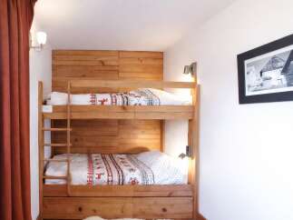 This cozy bedroom features a custom-built wooden bunk bed, perfect for accommodating guests or family members.