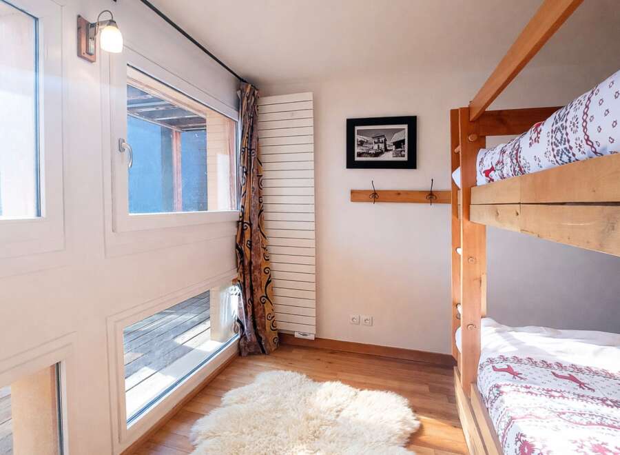This cozy bedroom features a charming bunk bed, perfect for accommodating guests or family members.