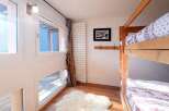 This cozy bedroom features a charming bunk bed, perfect for accommodating guests or family members.