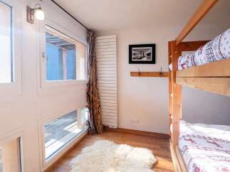 This cozy bedroom features a charming bunk bed, perfect for accommodating guests or family members.