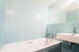 This modern bathroom features a sleek design with a bathtub and a sink.
