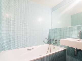 This modern bathroom features a sleek design with a bathtub and a sink.