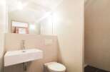 This modern bathroom features a sleek, minimalist design with a floating sink and a clean, white toilet.