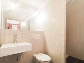 This modern bathroom features a sleek, minimalist design with a floating sink and a clean, white toilet.