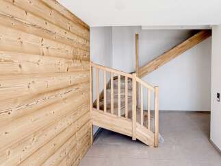 This stunning property features a beautifully crafted wooden staircase and accent wall, creating a warm and inviting atmosphere.