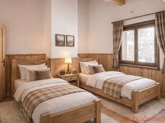 This cozy bedroom features two twin beds with wooden frames, perfect for a comfortable stay.