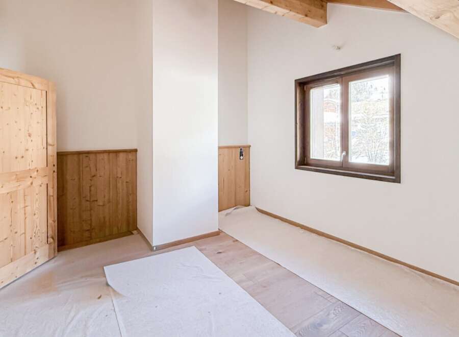 This charming room features a warm, inviting atmosphere with its natural wood door and trim.
