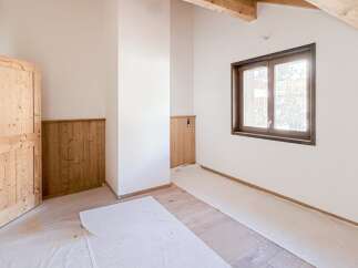 This charming room features a warm, inviting atmosphere with its natural wood door and trim.