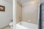 This bathroom features a clean and modern design with a white bathtub and beige tiled walls.