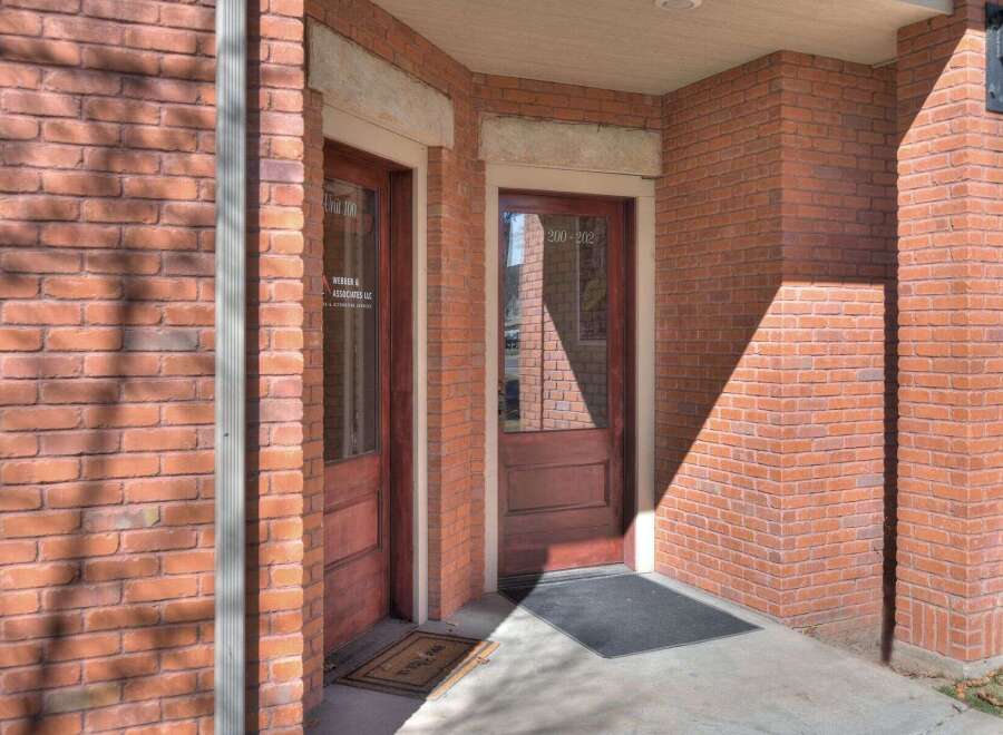 This charming brick building offers a welcoming entrance with two doors, perfect for a professional office space.