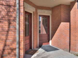 This charming brick building offers a welcoming entrance with two doors, perfect for a professional office space.