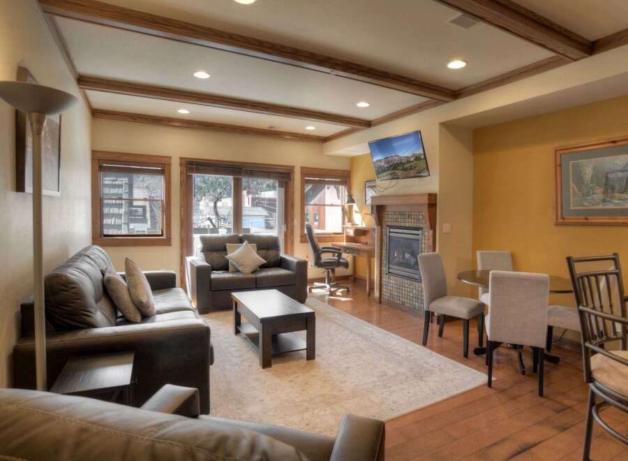Step into luxury with this stunning living space, featuring a cozy fireplace and a modern desk area, perfect for work or relaxation.