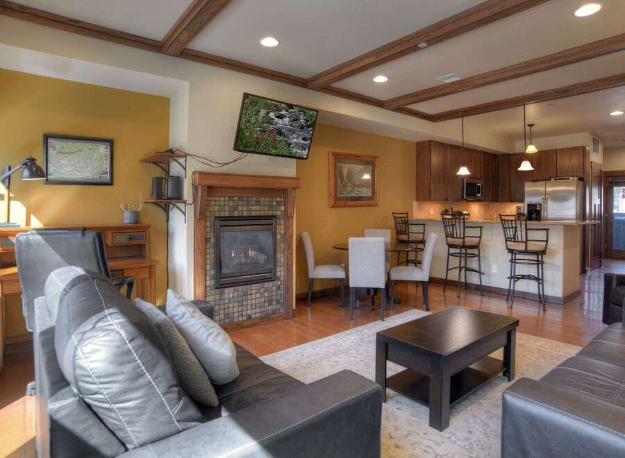 This stunning property boasts a cozy living room with a fireplace and a modern kitchen.
