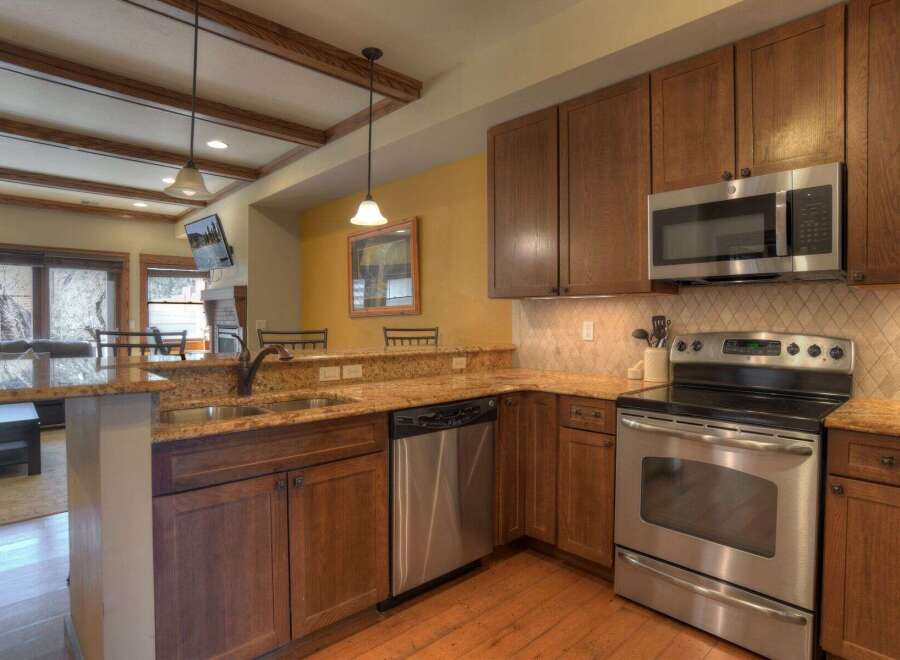 This stunning kitchen boasts beautiful wooden cabinetry and stainless steel appliances, creating a warm and inviting atmosphere.